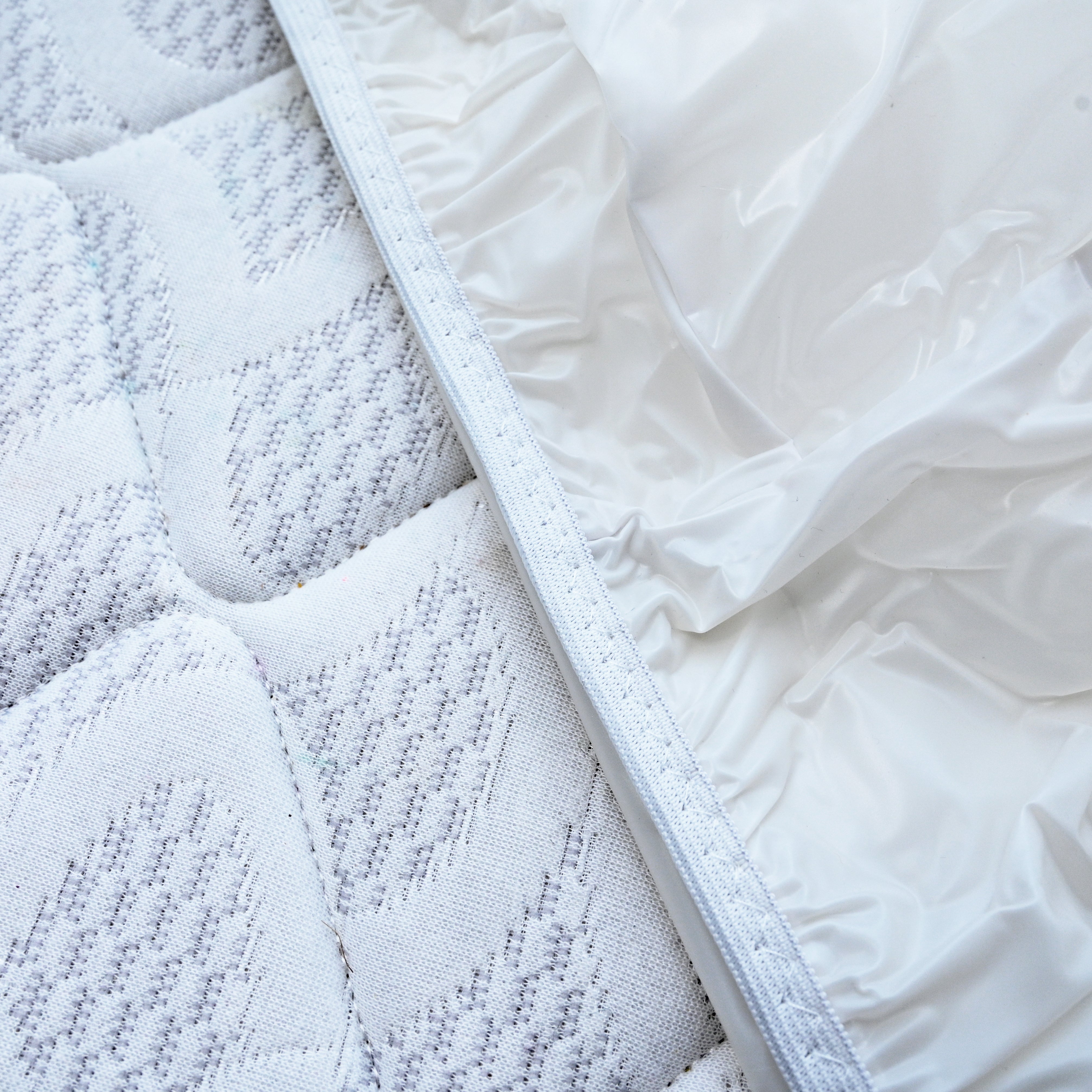 torn mattress protector elastic corner close up